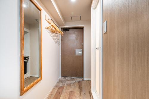 a hallway with a mirror and a door at Sleep Inn Gotanda in Tokyo