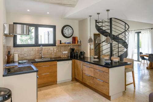 a kitchen with a counter and a clock on the wall at Bastide Blanche Villa with swimming pool and pétanque court in Lourmarin in Lourmarin