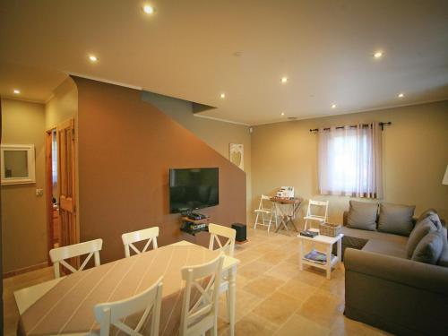 a living room with a couch and a table and a television at Villa in Lubéron with Saltwater Pool in Apt