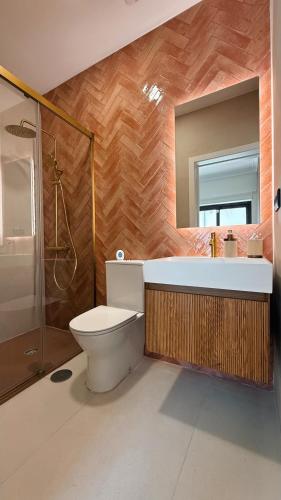 a bathroom with a toilet and a sink and a mirror at Gontim Boutique Stay in Viana do Castelo