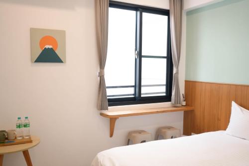a bedroom with a bed and a window at 有某行旅 yóu mǒu hostel in Tainan