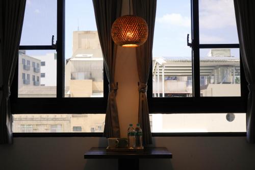 a window with a lamp and two bottles on a table at 有某行旅 yóu mǒu hostel in Tainan