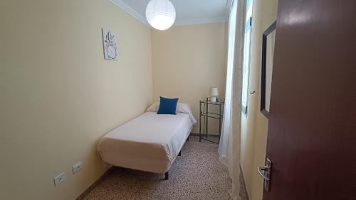 Un dormitorio pequeño con una cama con una almohada azul. en Casa Naos, en Puerto Naos