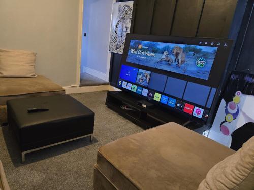 a living room with a flat screen tv and a couch at 30mins from Alton Towers - Panama Apartments Lodge in Stoke on Trent