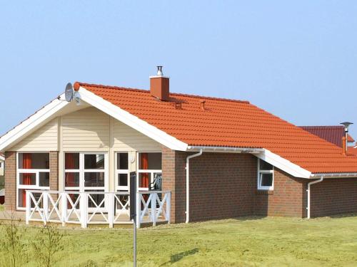 ein Backsteinhaus mit orangefarbenem Dach in der Unterkunft 6 person holiday home in Otterndorf in Otterndorf