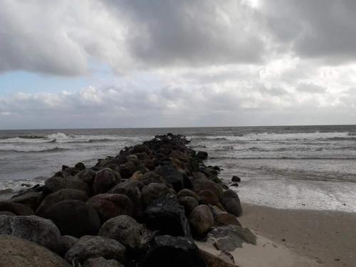a pile of rocks on a beach near the ocean at 8 person holiday home in Blåvand in Blåvand