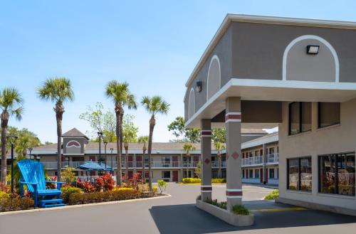 a view of the front of a hotel with palm trees at Hotel South Tampa & Suites in Tampa