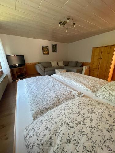 a bedroom with two beds and a couch at Haus Simon in Vogelsang