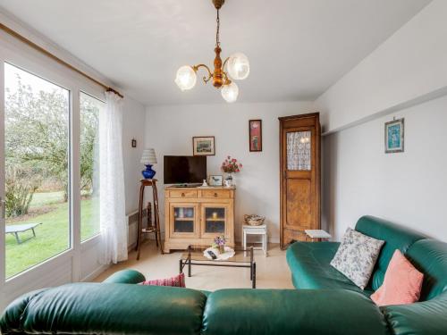 a living room with a green couch and a tv at Priziac Garden Hideaway in Priziac