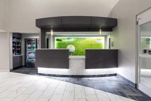 a lobby with a counter with a vase in a window at Wingate Augusta Washington Road by Wyndham in Augusta