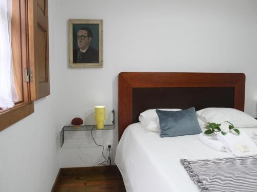 a bedroom with a bed and a portrait of a man at Cottage in Santa Comba with Pool in Ponte de Lima