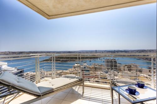 a balcony with chairs and a view of a ship at 16th Floor with Pool & 180 Sea Views by QuickTrips in Sliema
