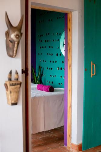 a room with a bed in a room with a wall at Chameleon Hill Forest Lodge in Bwindi