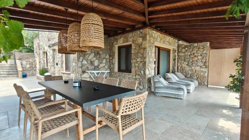 a patio with a black table and chairs at Andy's Place , Possidi By Halkidiki Villas in Possidi