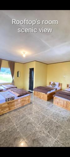a bedroom with two beds in a room at WISMA SUNRISE GUEST HOUSE 10 minutes by walking to the big fruit market in Berastagi in Berastagi