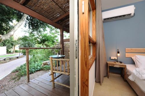 a room with a balcony with a bed and a table at Almog Hotel in Almog