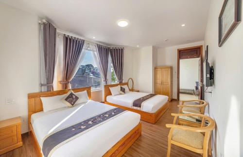 a hotel room with two beds and a window at Lan Viên Villa in Da Lat