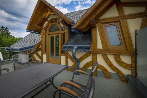 a house with a table and chairs on a balcony at Hotel Kocourkov in Hlinsko