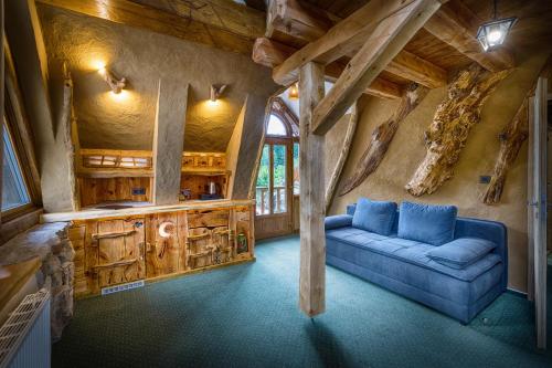 a living room with a blue couch in a cabin at Hotel Kocourkov in Hlinsko