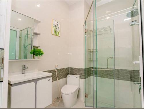a bathroom with a toilet and a glass shower at Bonita Boutique Hotel Q5 in Ho Chi Minh City