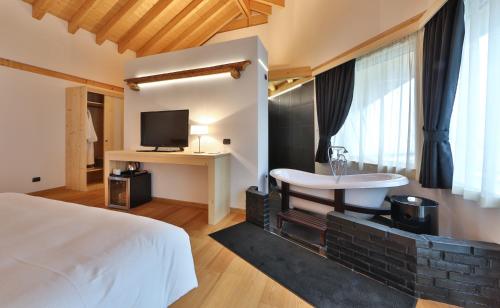 a bedroom with a bed and a sink and a tv at Hotel Alla Posta in Saint Vincent