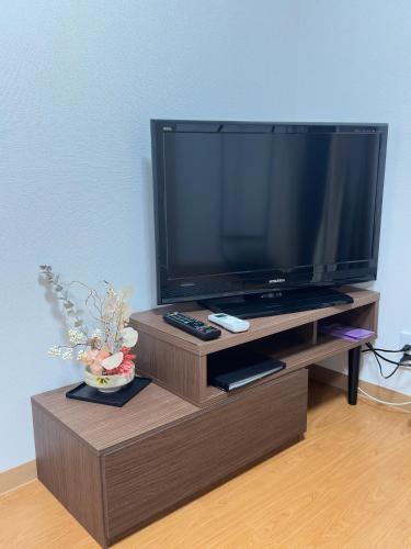 a large flat screen tv on a wooden entertainment center at Y K Kyoto Nijo Traditional House close to Arashiyama in Kyoto