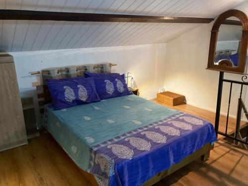 Un dormitorio con una cama con sábanas azules y un espejo. en Kreolia Blue, en Trou d'Eau Douce