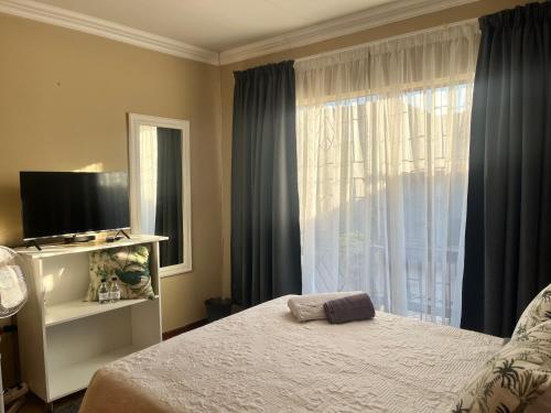 a bedroom with a bed and a large window at Guesthouse at 543 in Lebowakgomo