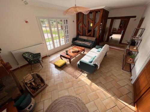 Saint-Hilaire-de-CourtにあるLe Poirier au Roi, Villa avec Piscine, Jacuzzi, Parc, Etang et calmeのソファとテーブル付きのリビングルームのオーバーヘッドビュー