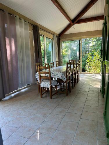 a screened in porch with a table and chairs at Chez Mamie in Cazes-Mondenard