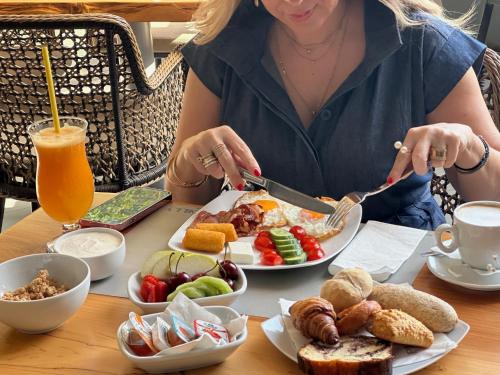 a woman sitting at a table with a plate of food at Piccadilly House in Arta