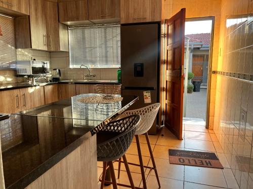 a kitchen with a counter and two stools at Guesthouse at 543 in Lebowakgomo