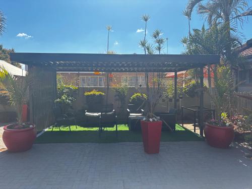 a patio with potted plants and a pergola at Guesthouse at 543 in Lebowakgomo