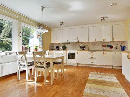 a kitchen with white cabinets and a table and chairs at 7 person holiday home in STRÅVALLA-By Traum in Löftabro