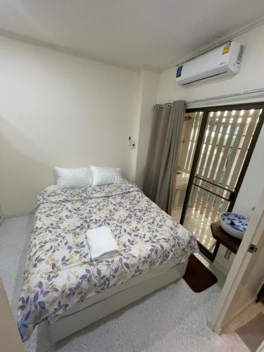 a bedroom with a bed and a balcony with a heater at Sairin 1 bedroom BTS Udomsuk in Bangna