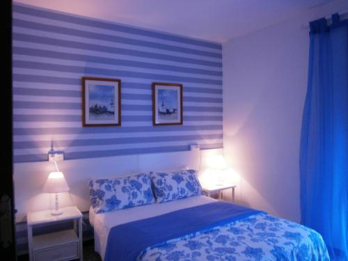 a bedroom with a blue striped wall with a bed at Hostal Don Pepe in Figueres