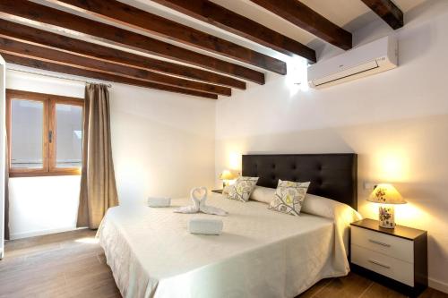 a bedroom with a large white bed with a window at Horta 55 in Pollença