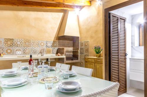 a dining room with a table and a kitchen at Horta 55 in Pollença