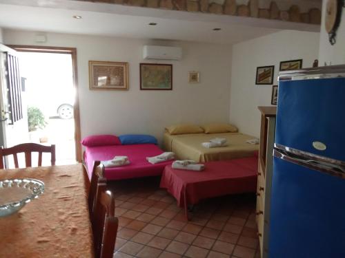 a living room with two beds and a refrigerator at Dea's House con parcheggio in Gaeta