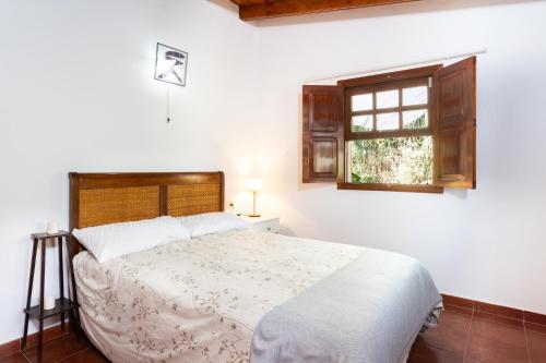a white bedroom with a bed and a window at OkStay - Casa Canaria en El Sauzal in Tacoronte