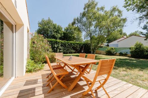 a wooden table and chairs on a deck at Chez Paddy - Familial - Paisible in Challans