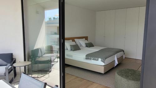 Un dormitorio con una cama, una silla y un espejo. en DelMar WaterFront DL, en Olhão