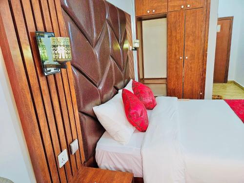 a bedroom with a bed with red pillows on it at Reiz Continental Hotel, Abuja in Abuja