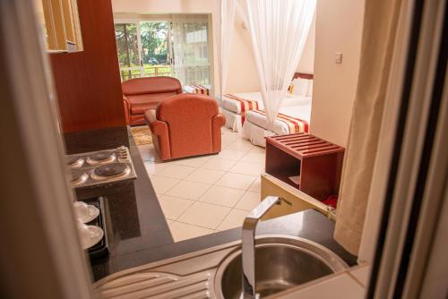 a kitchen with a sink and a living room at Bomah Hotel Limited in Gulu