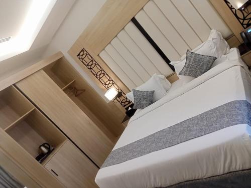 a bedroom with a large white bed in a room at Mora Hotel in Al Khobar