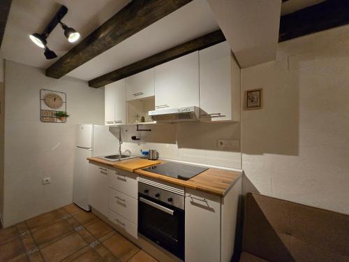 a kitchen with white cabinets and a stove top oven at La Cantarera del Duero in Tordesillas