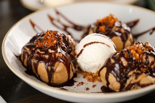 a white plate with ice cream and chocolate covered desserts at The Salthouse Hotel in Ballycastle