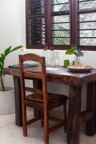a wooden table with a wooden chair and a wooden table with a wooden chair at Villa Juliana in Jambiani