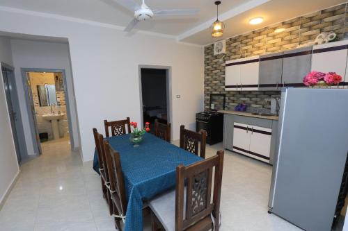 a kitchen and dining room with a blue table and chairs at nile shores hotel in Al Aqālitah