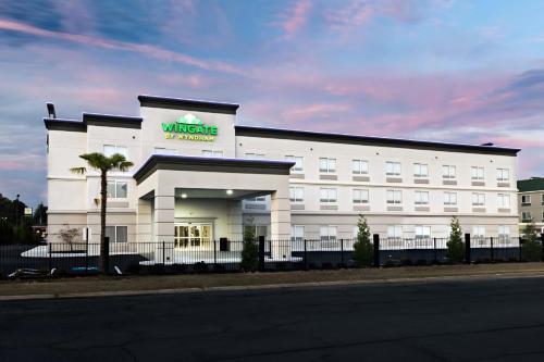 a white building with a sign on the front of it at Wingate Augusta Washington Road by Wyndham in Augusta